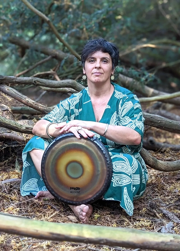 Cristina holding a Gong while seated in a Forest